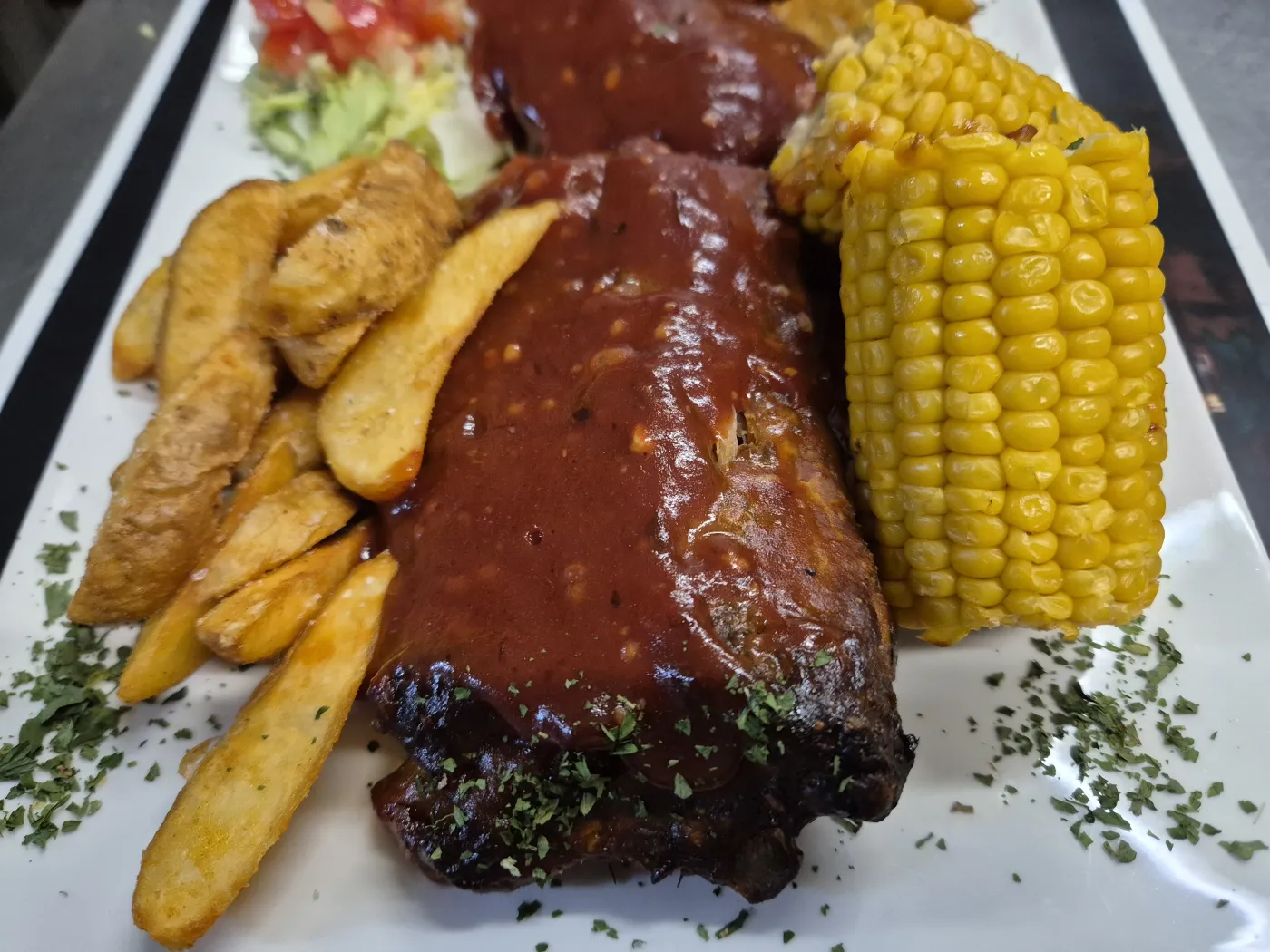 Costillitas de cerdo — svinjska rebra sa chili umakom, pečenim krumpirom i kukuruzom